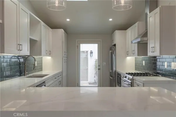 a kitchen with stainless steel appliances a refrigerator and a stove top oven