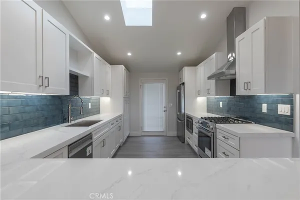 a kitchen with stainless steel appliances granite countertop a sink and a stove
