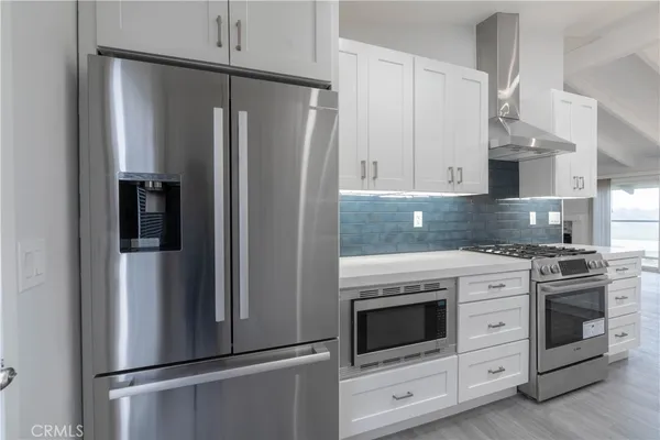 a kitchen with stainless steel appliances white cabinets and a refrigerator