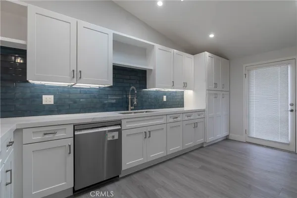 a kitchen with granite countertop white cabinets and white stainless steel appliances