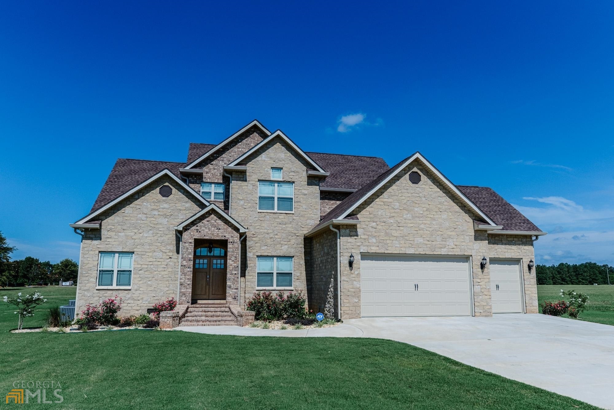a front view of a house with a garden and yard