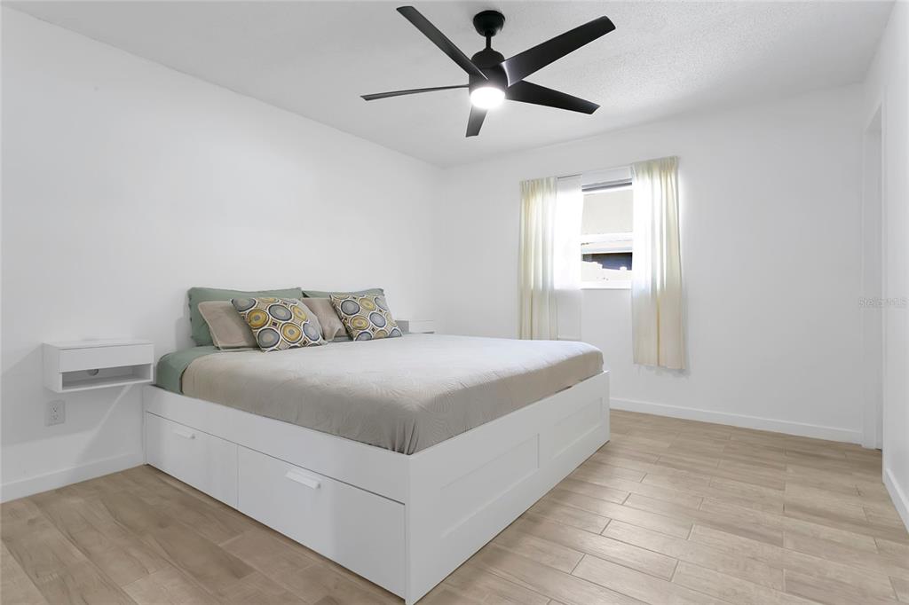 851 Darwin Drive Altamonte Springs, FL 32701 - Photo 11 of 31 a bedroom with a large bed and a ceiling fan