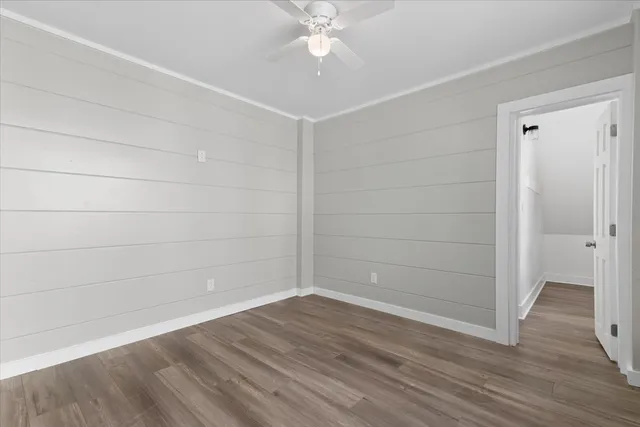 a view of a room with wooden floor and fan