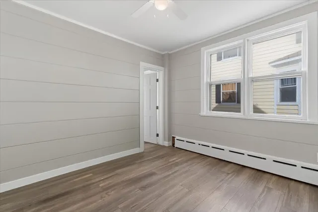 a view of a small space with wooden floor and a window