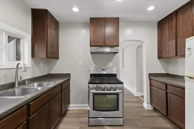 a kitchen with stainless steel appliances granite countertop a stove a sink and a microwave