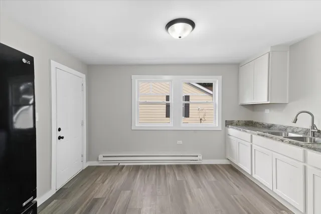 a view of a kitchen with sink and dishwasher with wooden floor