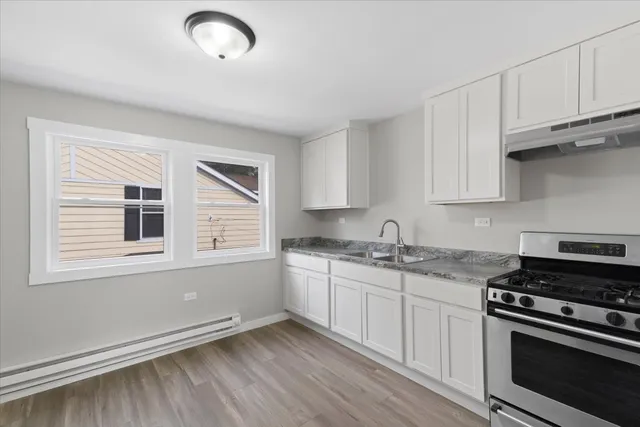 a kitchen with granite countertop a stove and a sink