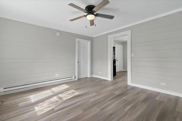 a view of a livingroom with a ceiling fan wooden floor and a ceiling fan
