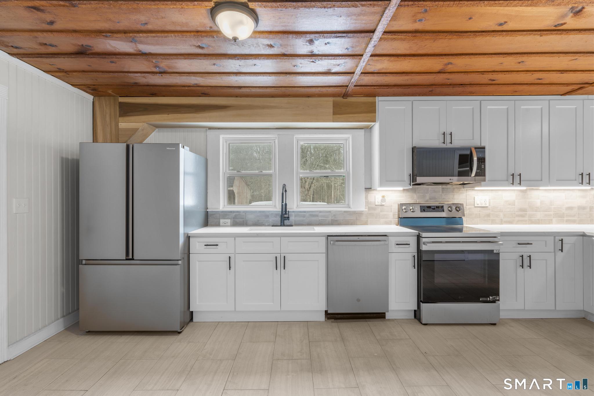 165 Ballamahack Road Windham, CT 06280 - Photo 8 of 40 a kitchen with white cabinets and stainless steel appliances