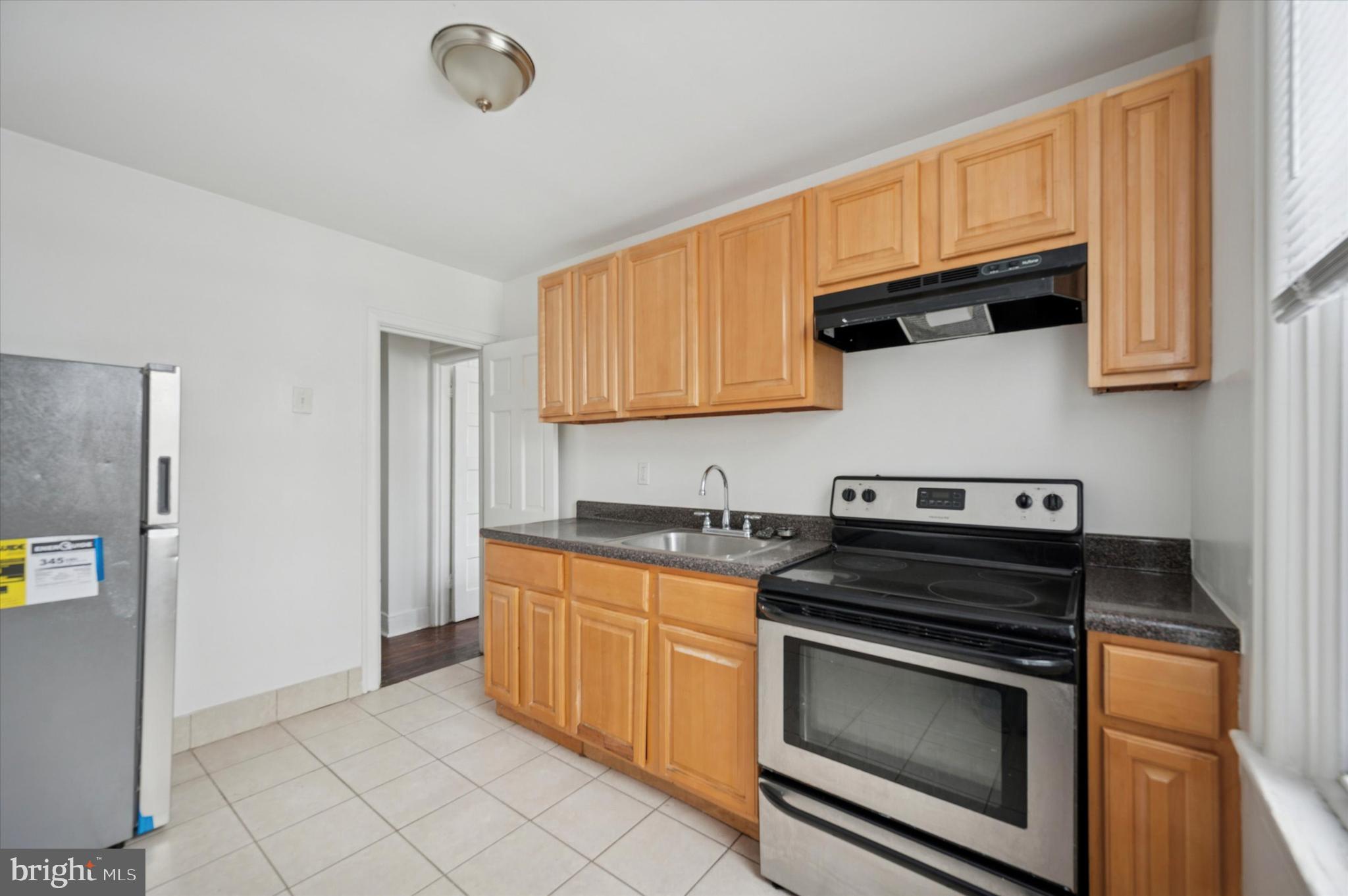 2000 Widener Place, Unit 1 Philadelphia, PA 19138 - Photo 8 of 15 a kitchen with granite countertop a stove sink and cabinets