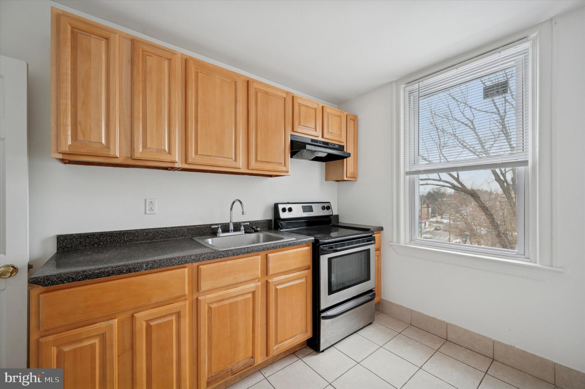 2000 Widener Place, Unit 1 Philadelphia, PA 19138 - Photo 9 of 15 a kitchen with stainless steel appliances granite countertop a stove a sink dishwasher and cabinets with wooden floor