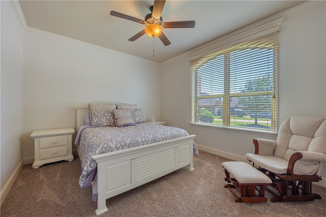 3301 Covington Court Bryan, TX 77808 - Photo 14 of 26 a spacious bedroom with a bed a couch and a chandelier