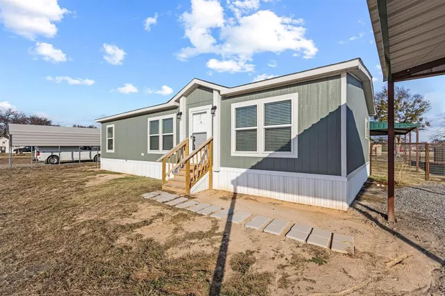 a view of a house with backyard and sitting area