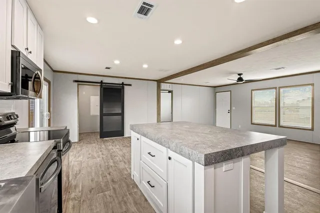 a kitchen with a sink refrigerator and wooden floor