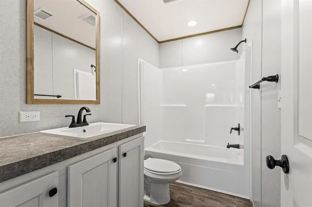 a bathroom with a granite countertop sink a toilet and shower