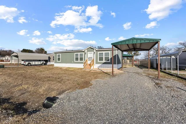 a view of a house with a patio and a yard