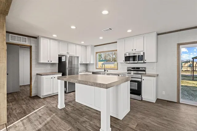 a kitchen with white cabinets and stainless steel appliances