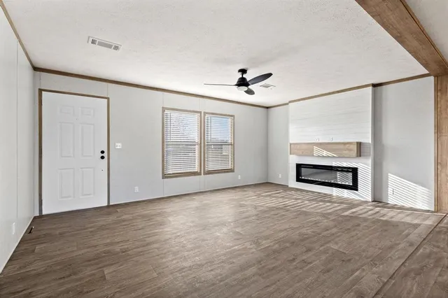 a view of an empty room with a fireplace and a window