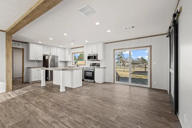 a kitchen with stainless steel appliances kitchen island wooden cabinets and granite counter tops