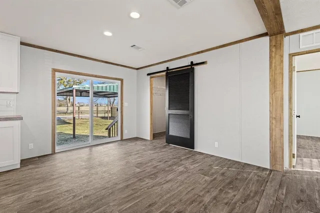 an empty room with wooden floor and sliding door