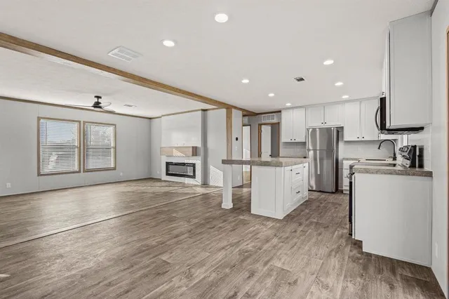 a view of kitchen with refrigerator microwave and stove top oven