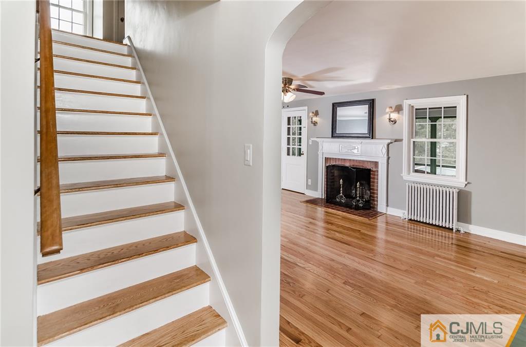 127 Plainsboro Road Cranbury, NJ 08512 - Photo 3 of 25 a view of an empty room with wooden floor fireplace and a window