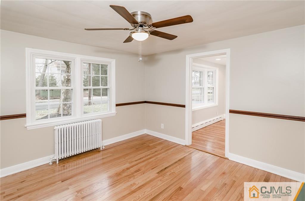 127 Plainsboro Road Cranbury, NJ 08512 - Photo 7 of 25 an empty room with wooden floor fan and windows