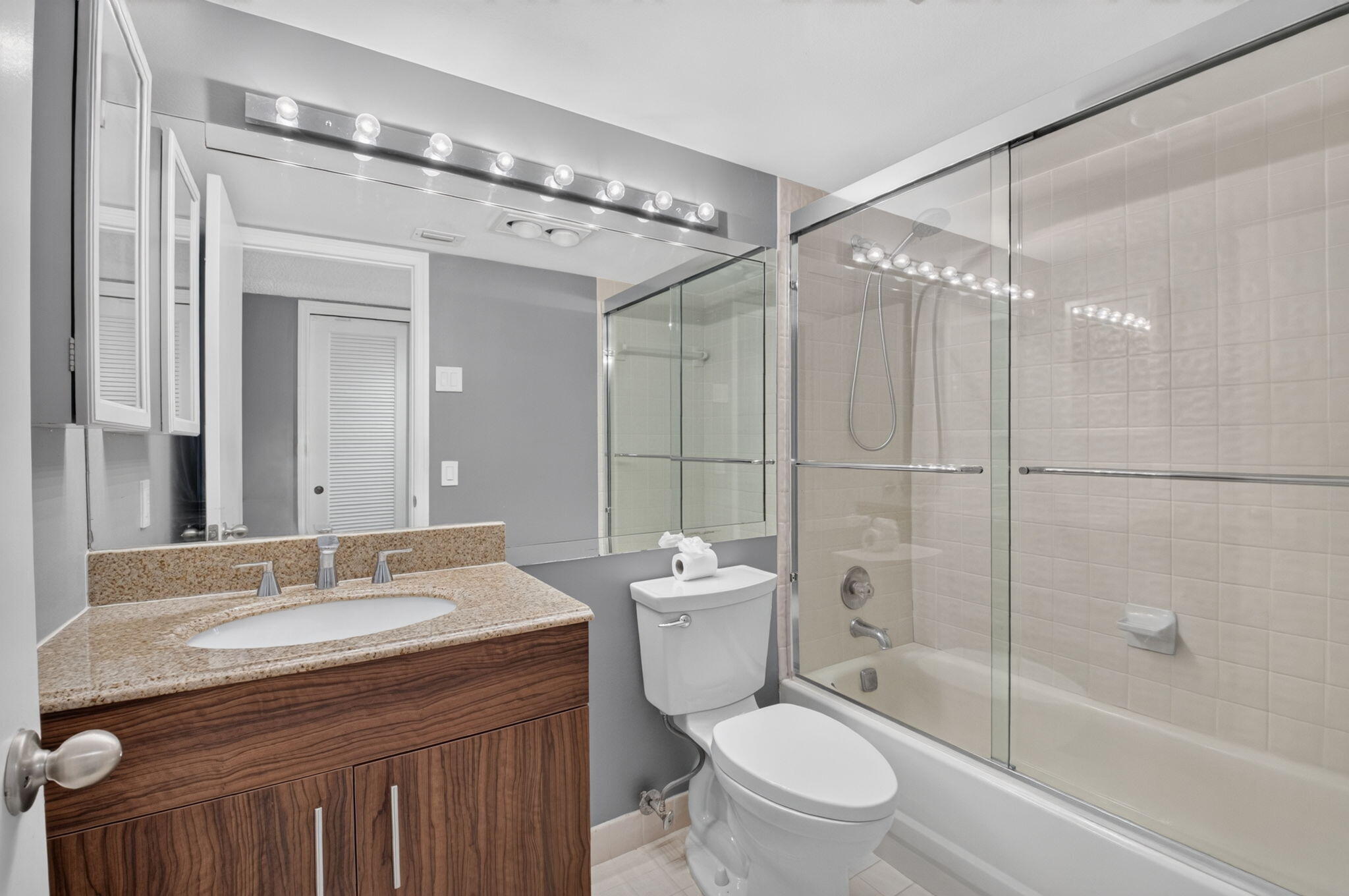 1401 South Ocean Boulevard, Unit 1060 Boca Raton, FL 33432 - Photo 24 of 46 a bathroom with a granite countertop sink toilet mirror and shower