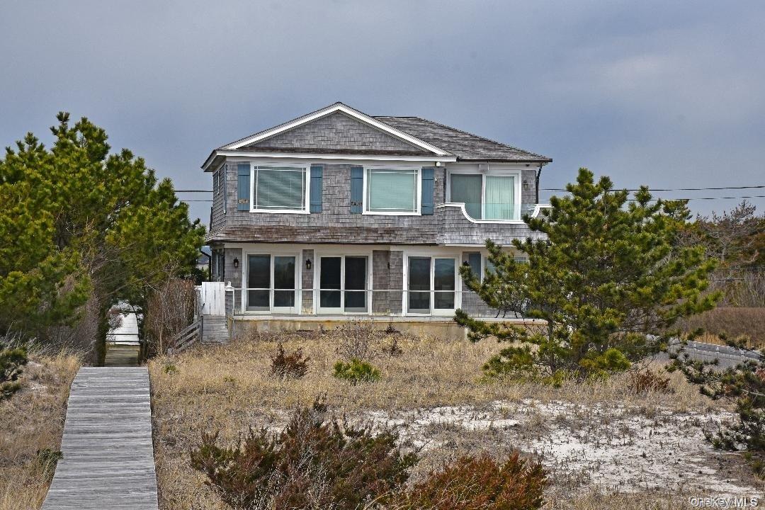493 Dune Road Westhampton Beach, NY 11978 - Photo 2 of 11 a front view of a house with a yard and trees