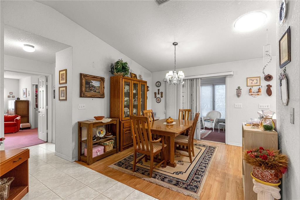 8534 Southwest 108th Pl Road Ocala, FL 34481 - Photo 15 of 41 a view of a dining room with furniture a chandelier and wooden floor