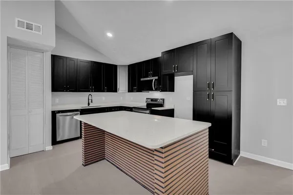a kitchen with a appliances a sink and cabinets