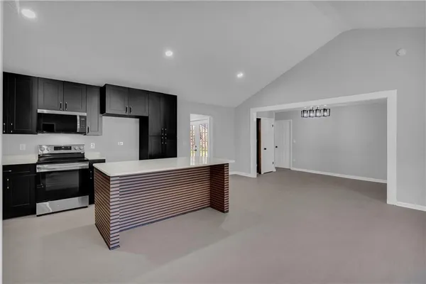 a kitchen with stainless steel appliances a refrigerator and a stove top oven