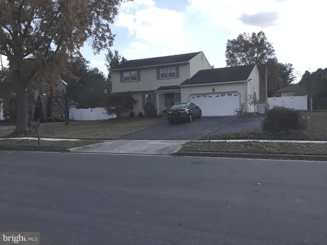 a view of a house with a yard and a street