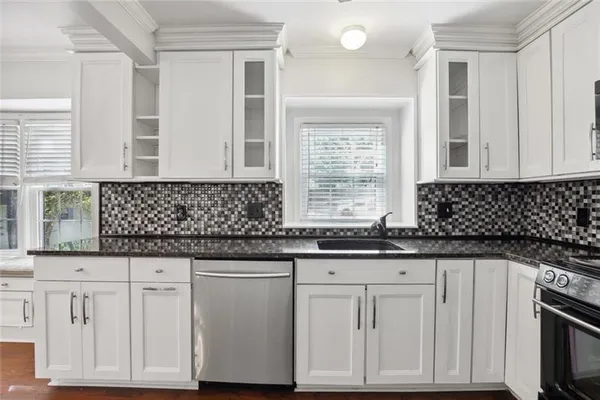 a kitchen with granite countertop white cabinets and sink