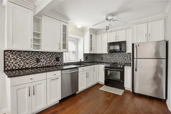 a kitchen with granite countertop white cabinets and white appliances