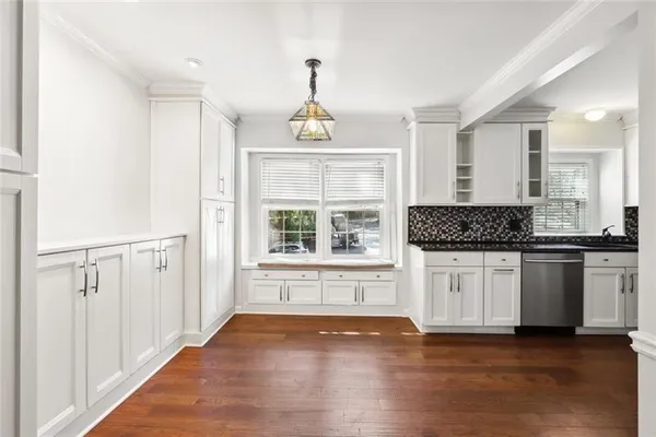 a kitchen with granite countertop white cabinets and window