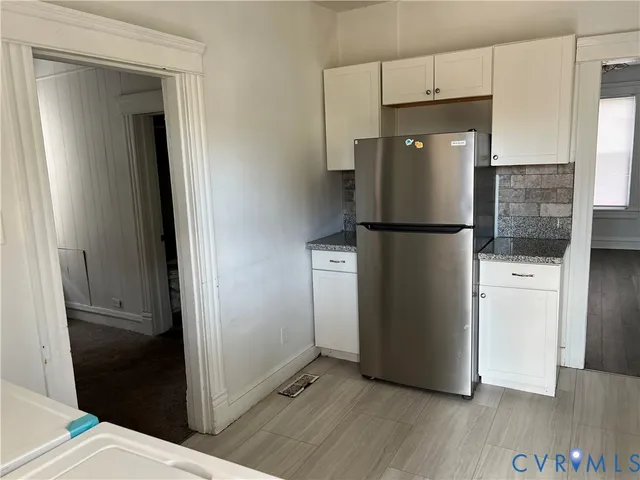 a white refrigerator freezer and a stove sitting inside of a kitchen