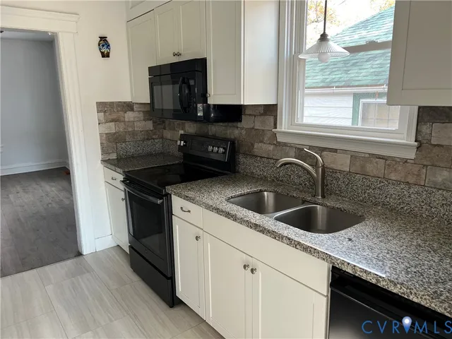 a kitchen with granite countertop a sink and a stove