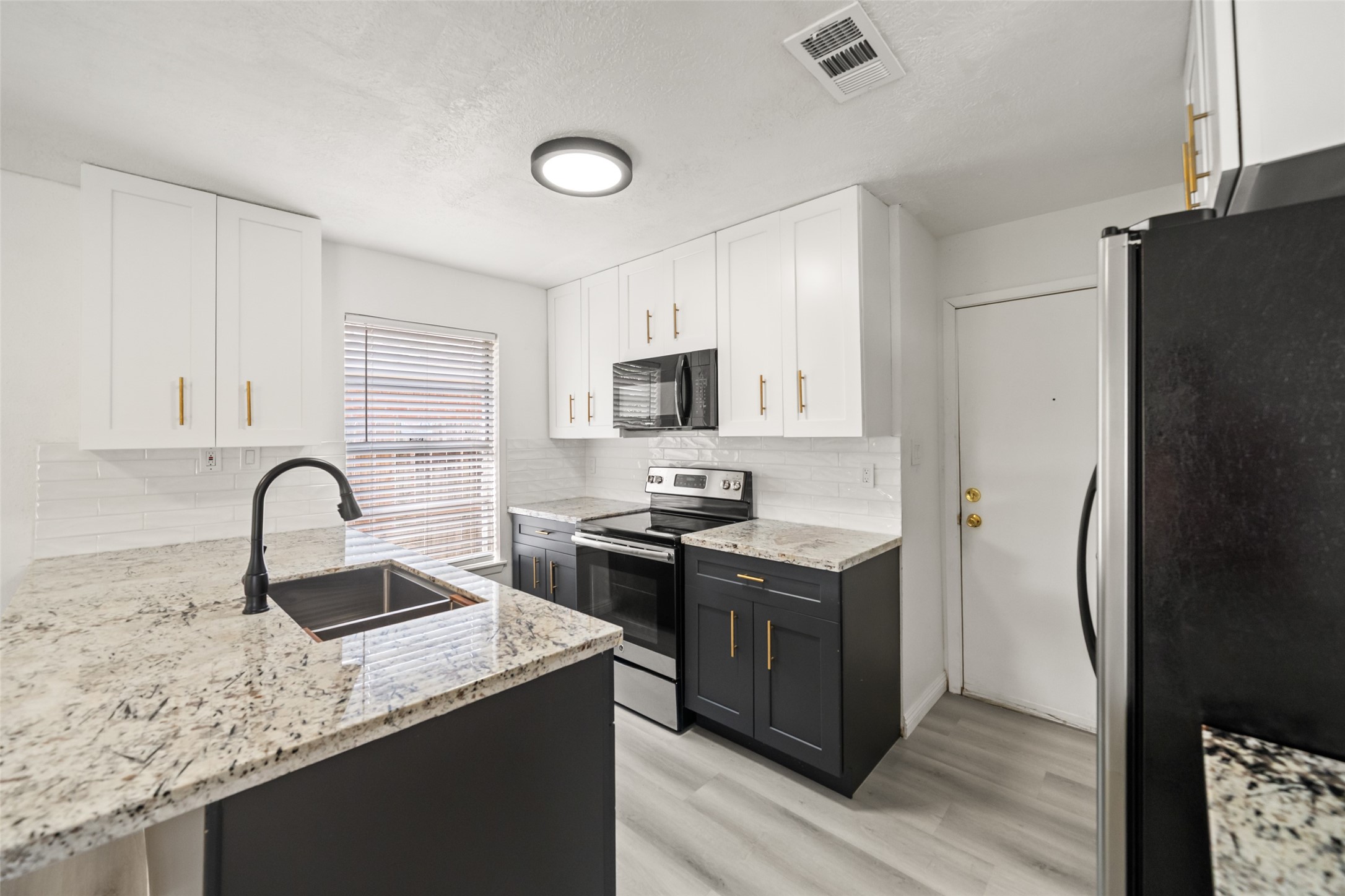 5726 Yorkgate Drive Spring, TX 77373 - Photo 9 of 20 a kitchen with stainless steel appliances granite countertop a sink stove and refrigerator