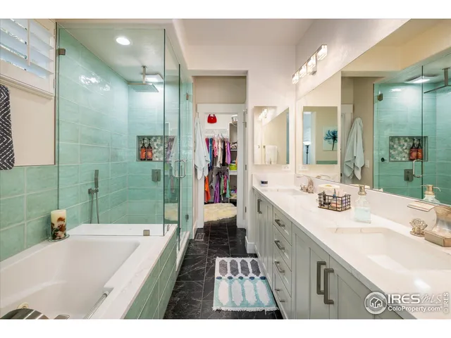 a bathroom with a sink double vanity granite tub shower and a mirror