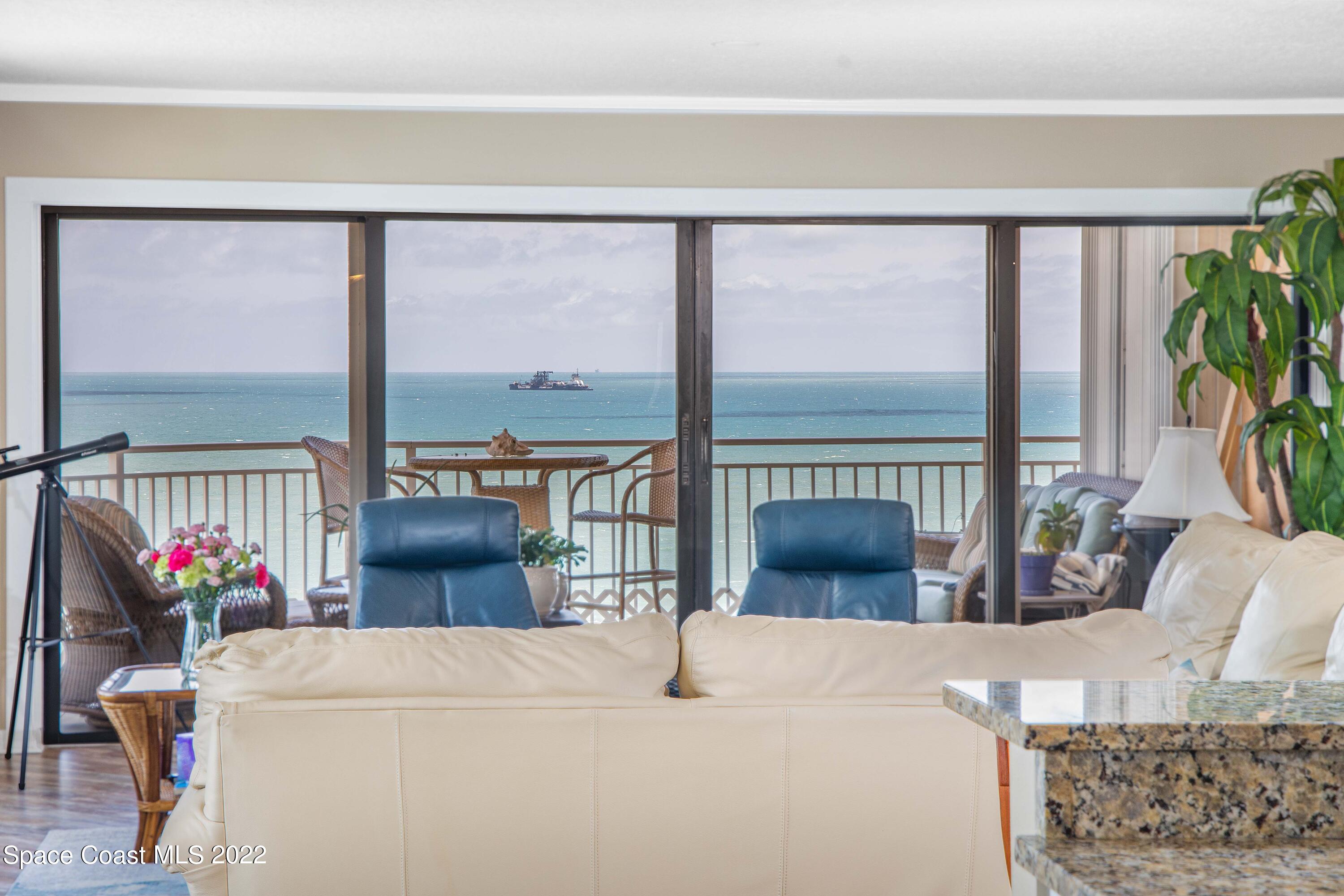 6770 Ridgewood Avenue, Unit 1001 Cocoa Beach, FL 32931 - Photo 12 of 57 a living room with furniture and a floor to ceiling window