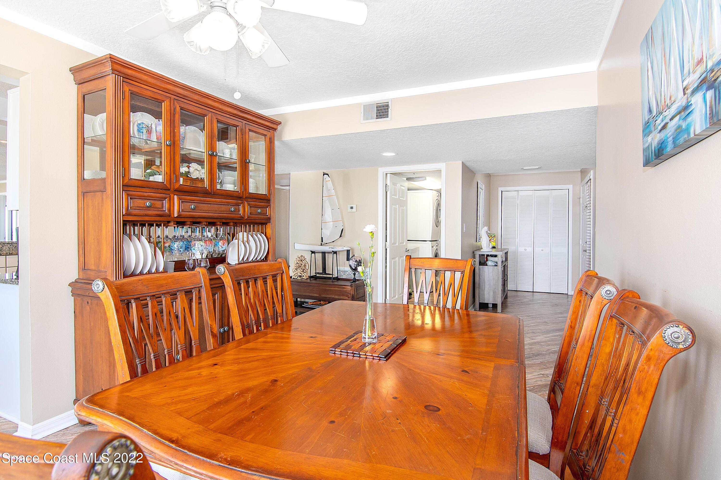6770 Ridgewood Avenue, Unit 1001 Cocoa Beach, FL 32931 - Photo 19 of 57 a dining room with furniture a rug and a chandelier