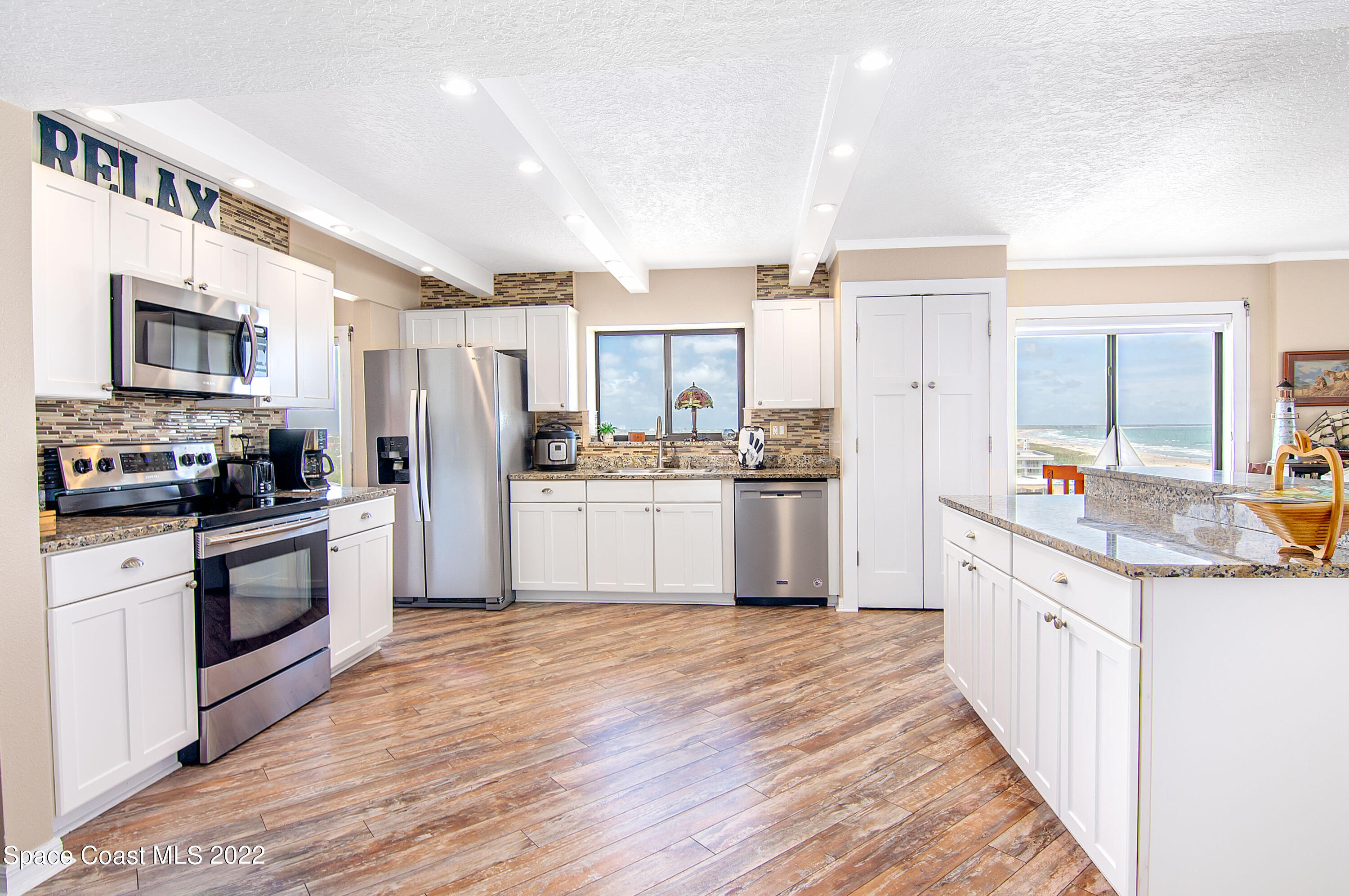 6770 Ridgewood Avenue, Unit 1001 Cocoa Beach, FL 32931 - Photo 21 of 57 a kitchen with stainless steel appliances a refrigerator sink and cabinets