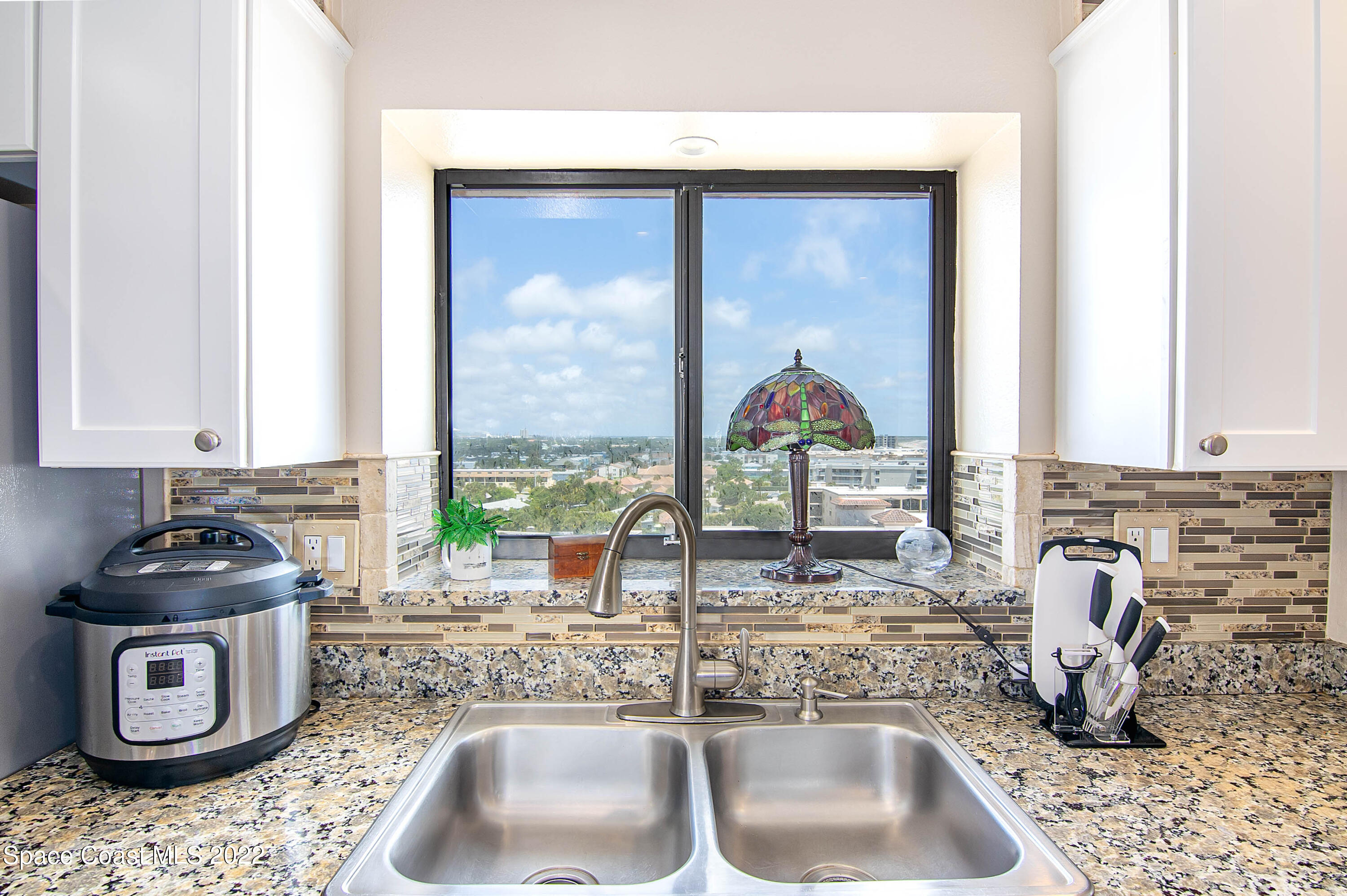 6770 Ridgewood Avenue, Unit 1001 Cocoa Beach, FL 32931 - Photo 22 of 57 a bathroom with a sink a vanity and a window