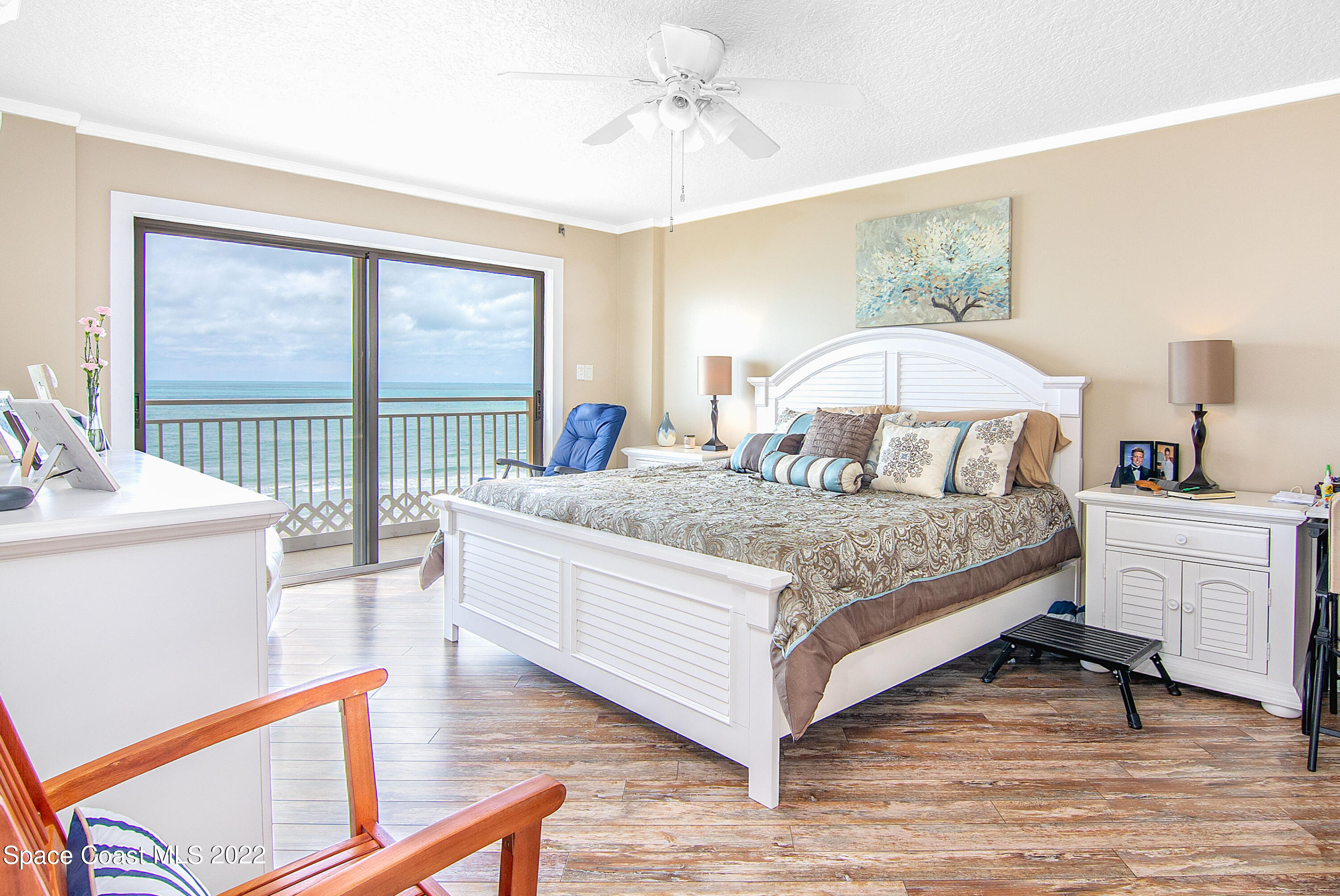 6770 Ridgewood Avenue, Unit 1001 Cocoa Beach, FL 32931 - Photo 23 of 57 a bedroom with a large bed and a chandelier
