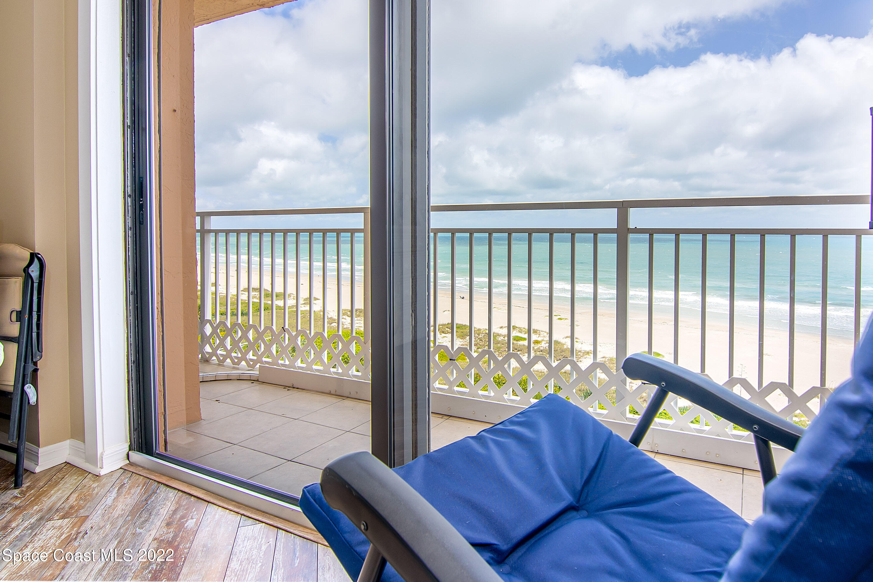 6770 Ridgewood Avenue, Unit 1001 Cocoa Beach, FL 32931 - Photo 25 of 57 a living room with furniture and a floor to ceiling window