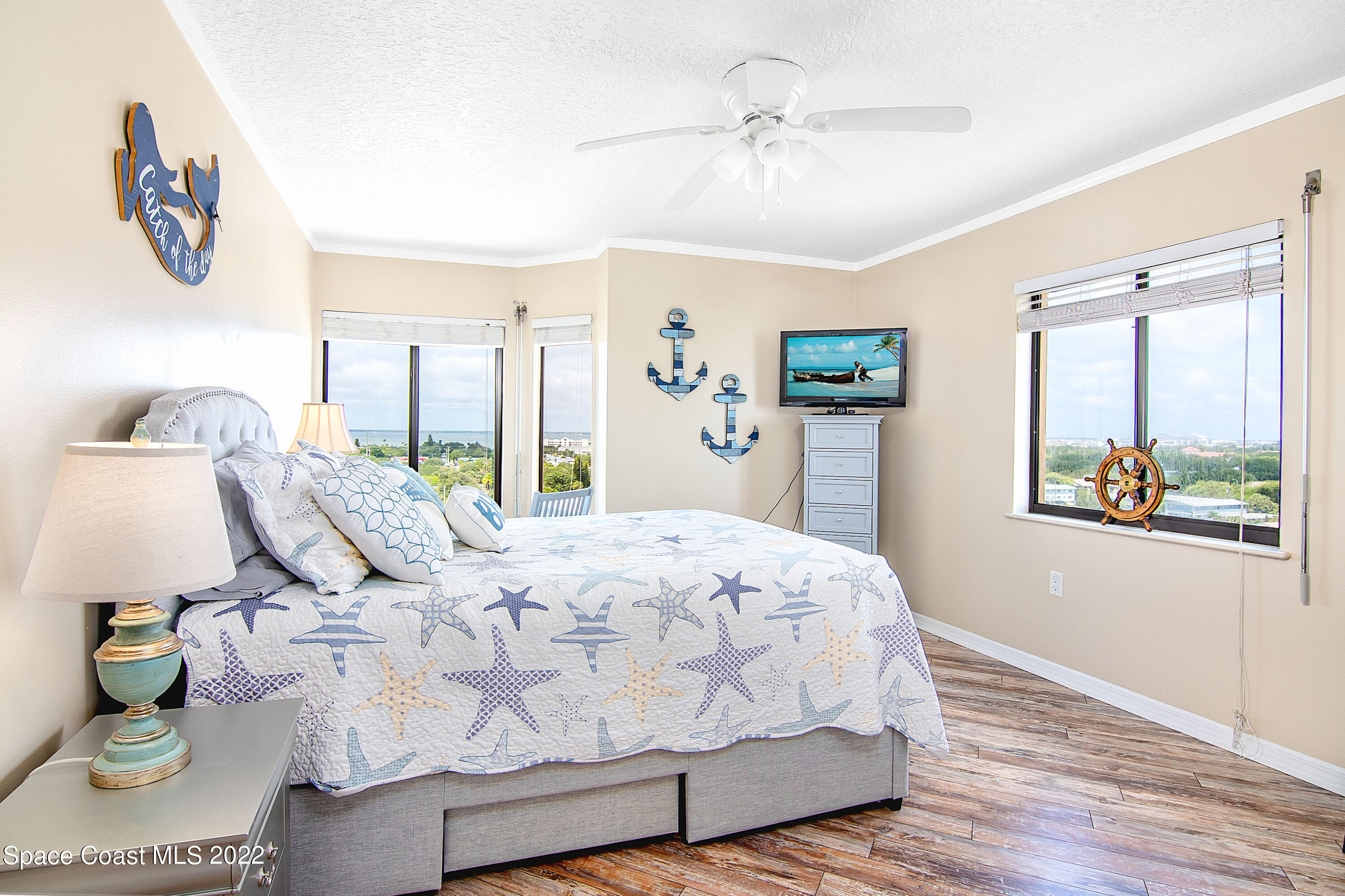 6770 Ridgewood Avenue, Unit 1001 Cocoa Beach, FL 32931 - Photo 30 of 57 a bedroom with a bed lamps and window