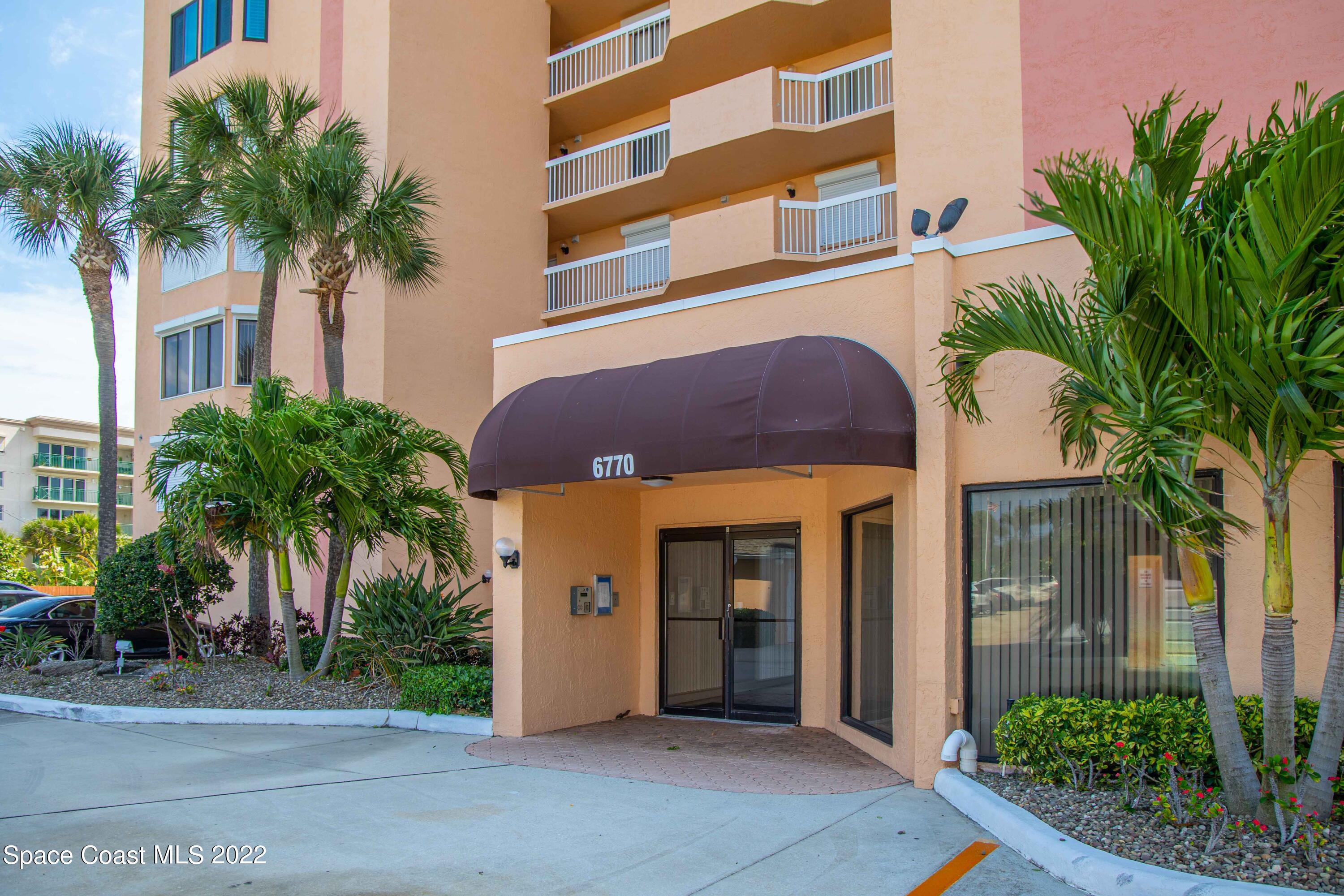 6770 Ridgewood Avenue, Unit 1001 Cocoa Beach, FL 32931 - Photo 44 of 57 a view of a building with a palm plants