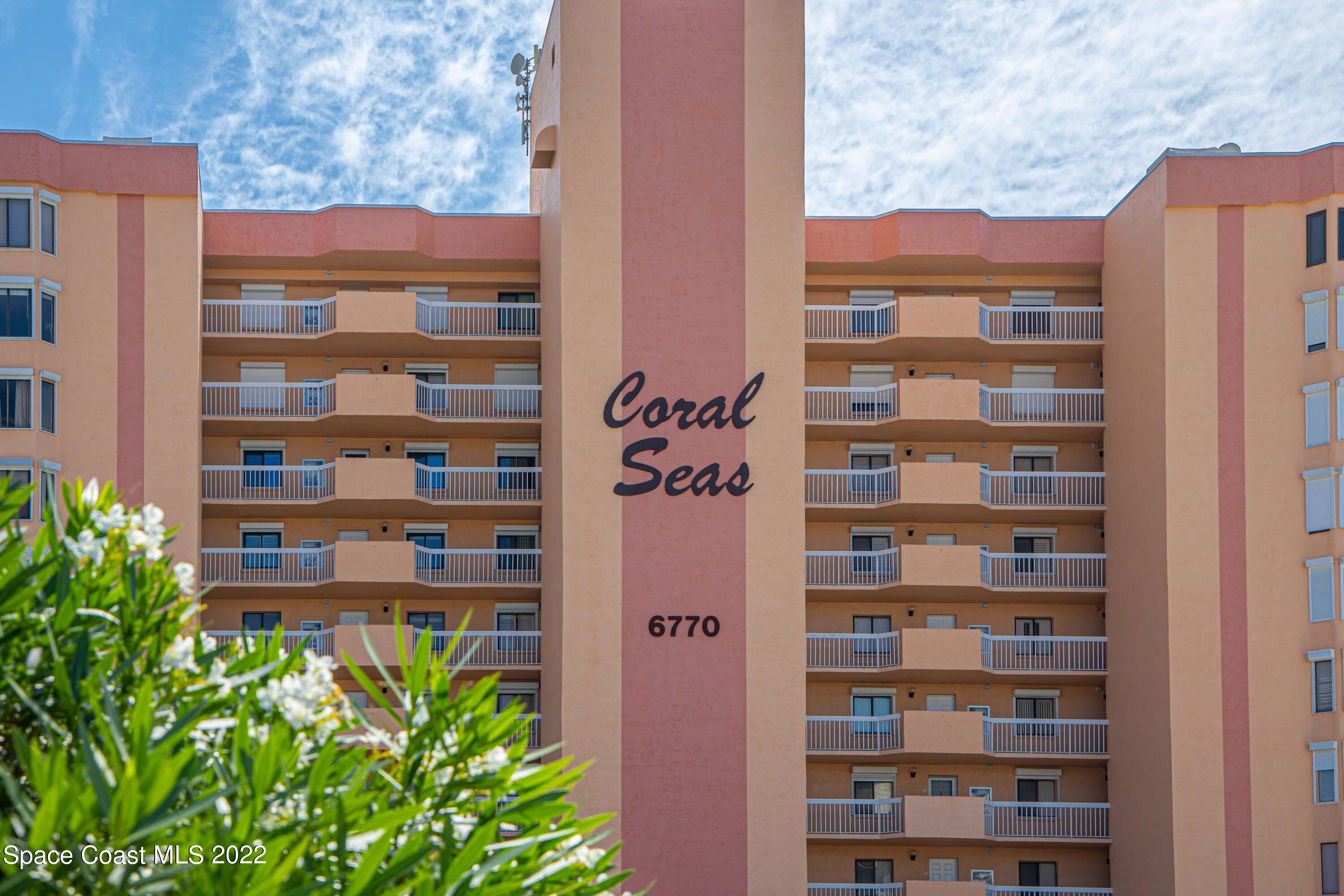 6770 Ridgewood Avenue, Unit 1001 Cocoa Beach, FL 32931 - Photo 56 of 57 a front view of a building with a garden