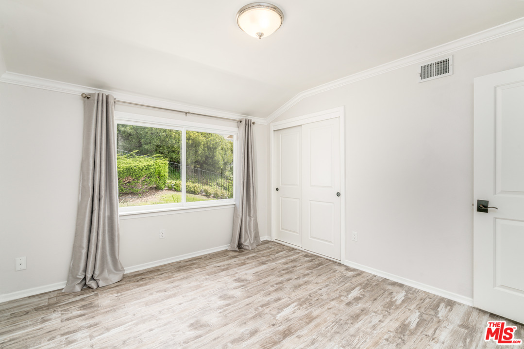 6267 Tapia Drive Malibu, CA 90265 - Photo 11 of 16 a view of an empty room with wooden floor and a window